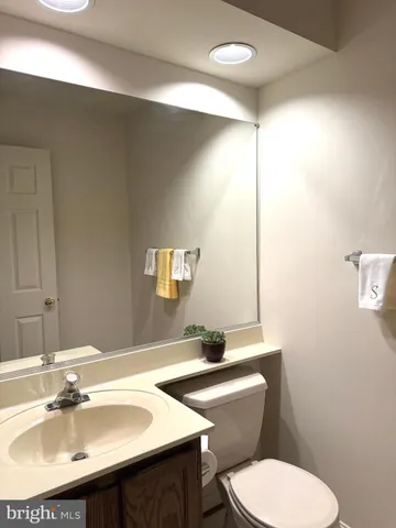 a bathroom with a toilet a sink and mirror