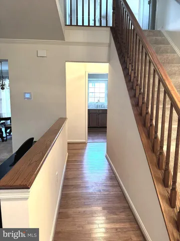 a view of a hallway with wooden floor and stairs