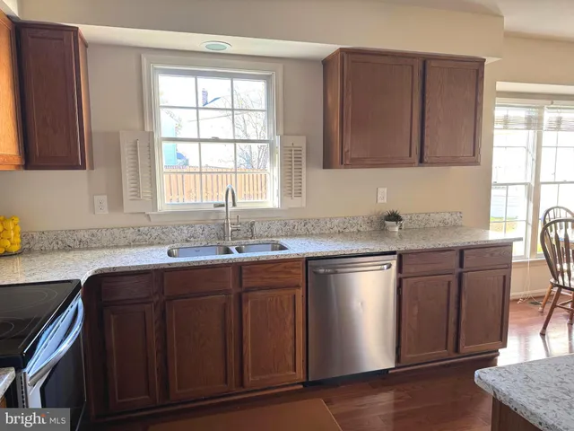 a kitchen with stainless steel appliances granite countertop a sink stove and cabinets