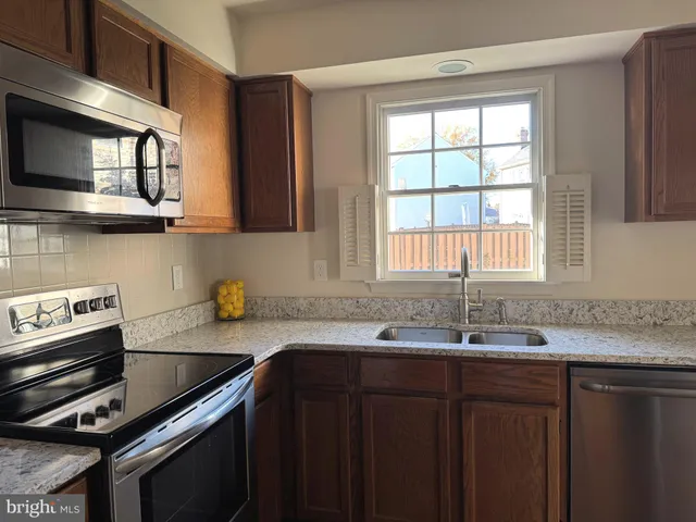 a kitchen with stainless steel appliances a sink stove and microwave