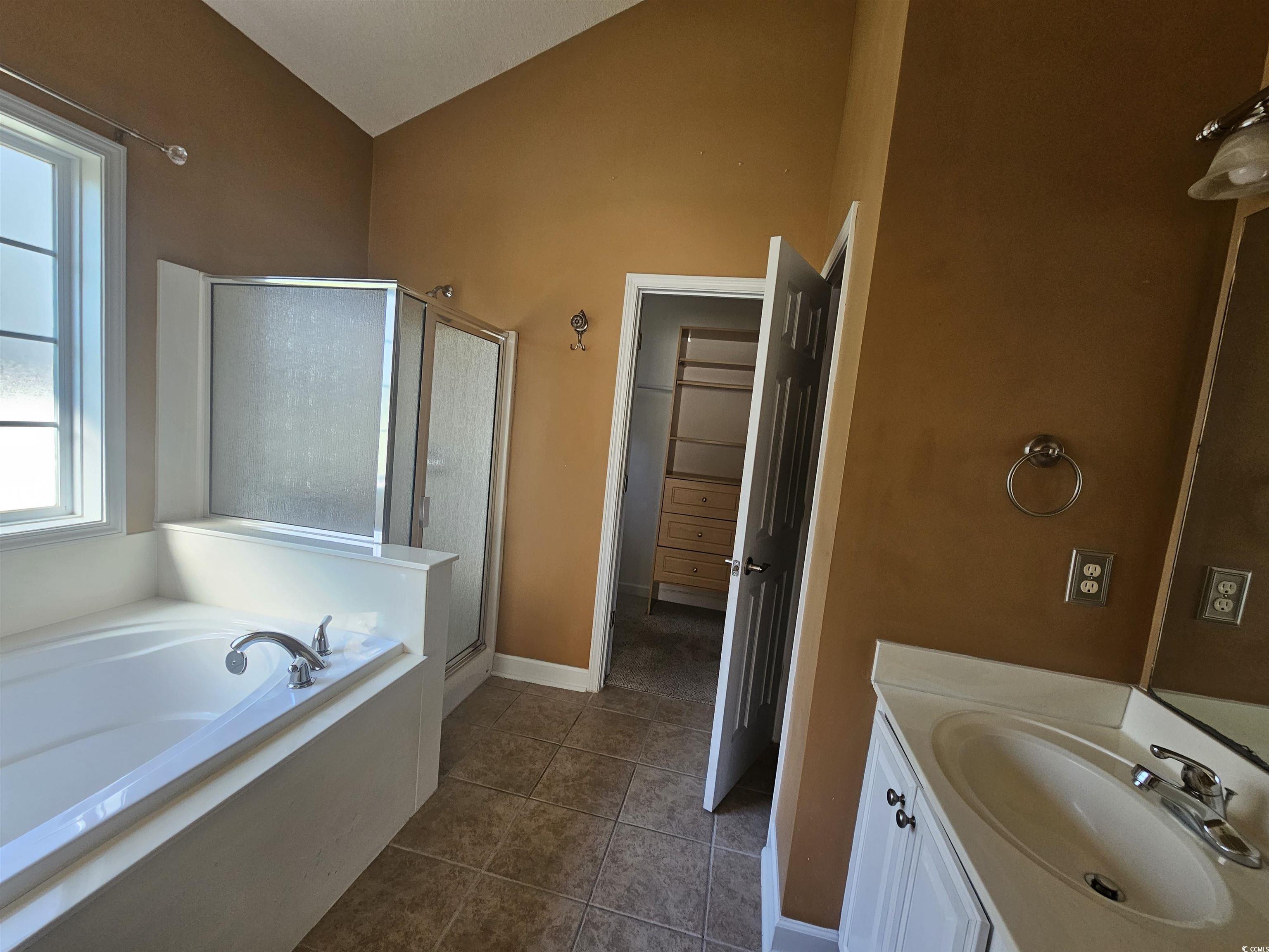 1011 Hillsdale Little River, SC 29566 - Photo 15 of 21 Full bathroom with vaulted ceiling, a shower stall, a bath, vanity, and dark tile patterned floors