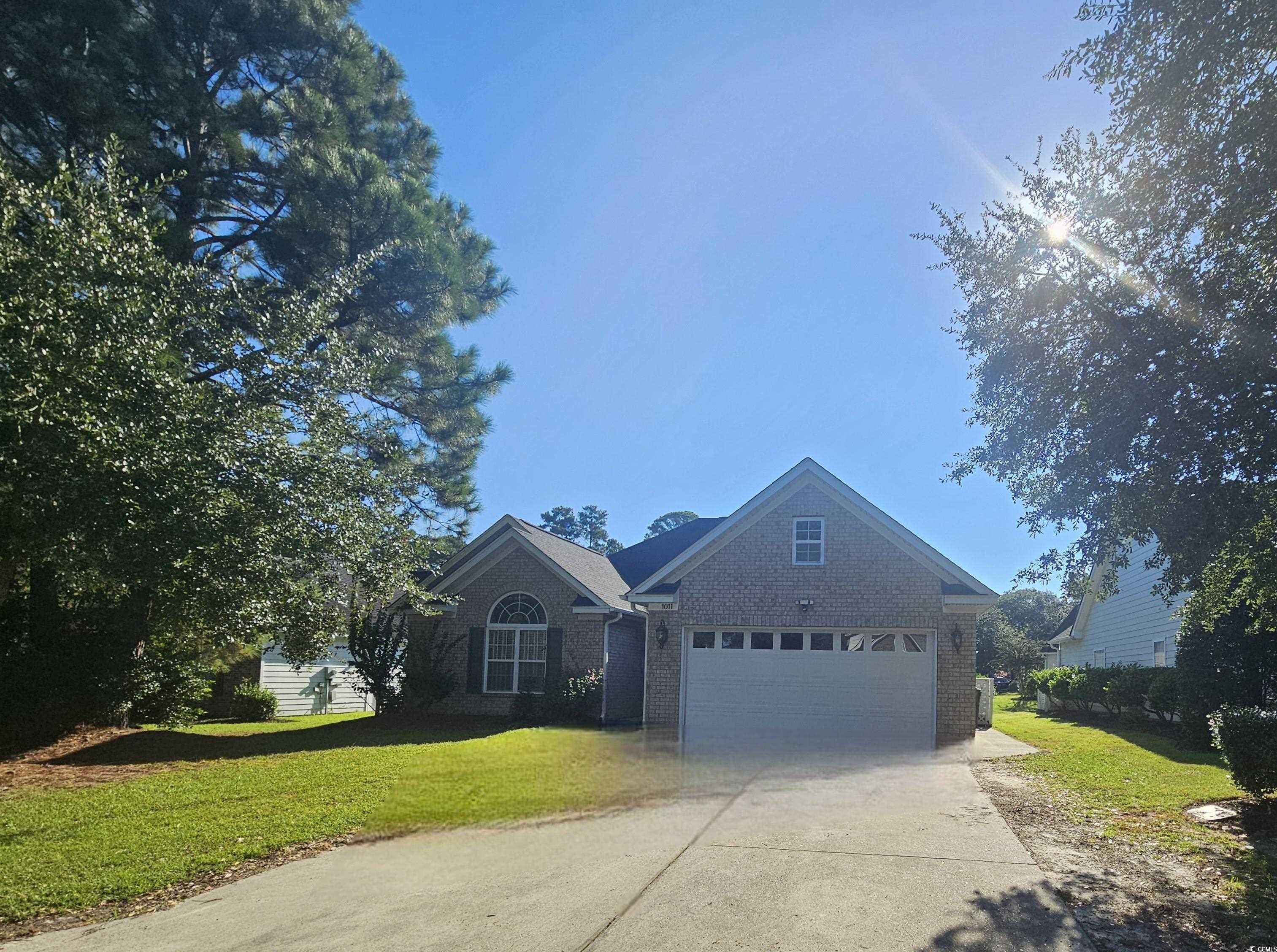 1011 Hillsdale Little River, SC 29566 - Photo 20 of 21 View of front facade featuring driveway, a front yard, brick siding, and a garage