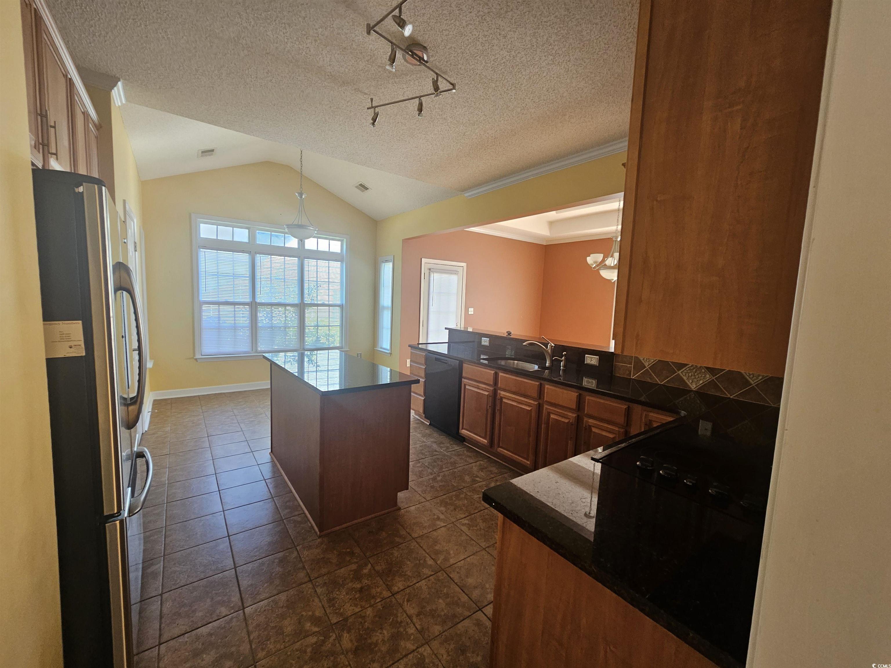 1011 Hillsdale Little River, SC 29566 - Photo 7 of 21 Kitchen featuring vaulted ceiling, freestanding refrigerator, a center island, brown cabinetry, and hanging light fixtures