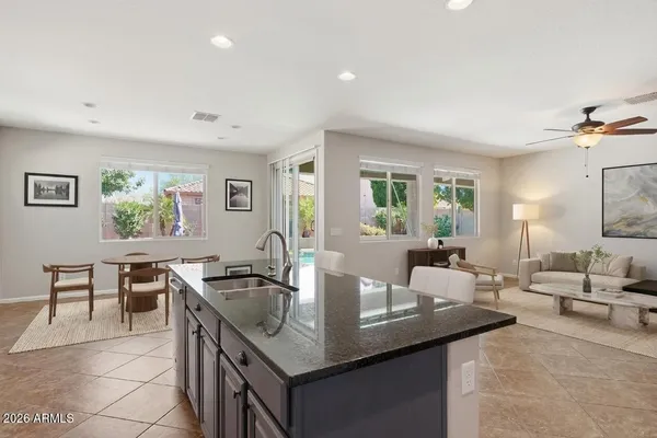 a kitchen with stainless steel appliances granite countertop a stove a sink dishwasher a refrigerator and white cabinets with wooden floor