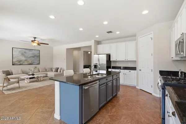 a kitchen with stainless steel appliances granite countertop a sink a stove top oven a counter space and cabinets