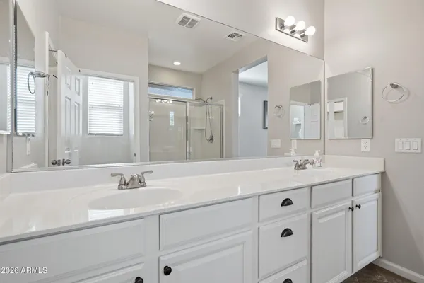 a bathroom with double sink and a mirror