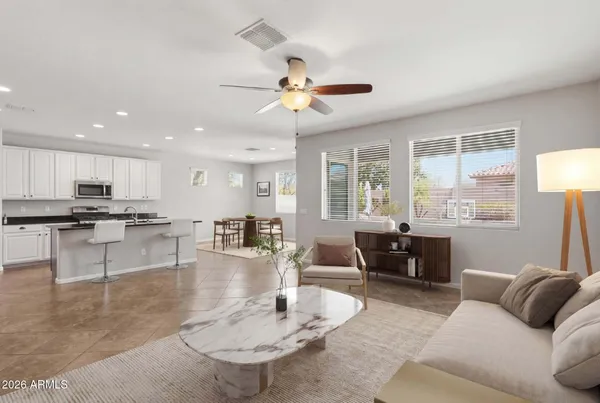 a living room with furniture kitchen view and a chandelier