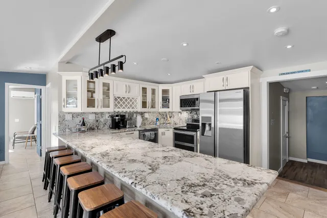 a bathroom with a granite countertop sink mirror and cabinets