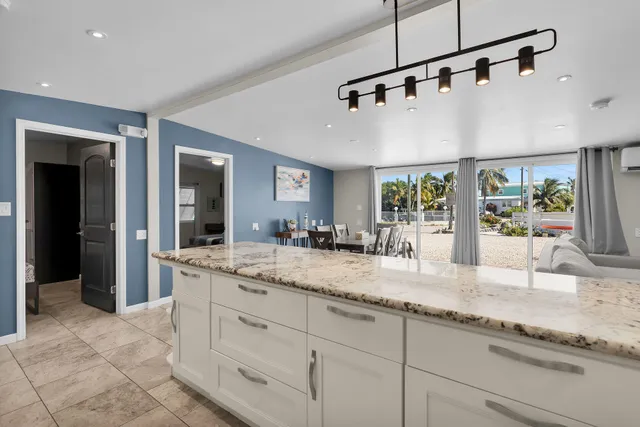 a large kitchen with stainless steel appliances kitchen island granite countertop a refrigerator and a stove top oven