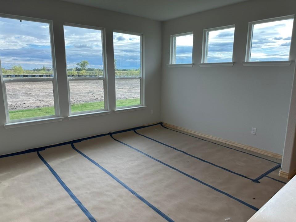 210 Horizon Rd Valley View Valley View, TX 76272 - Photo 9 of 23 Room featuring multiple tall windows, additional upper windows, light-toned wall paint, and unfinished flooring
