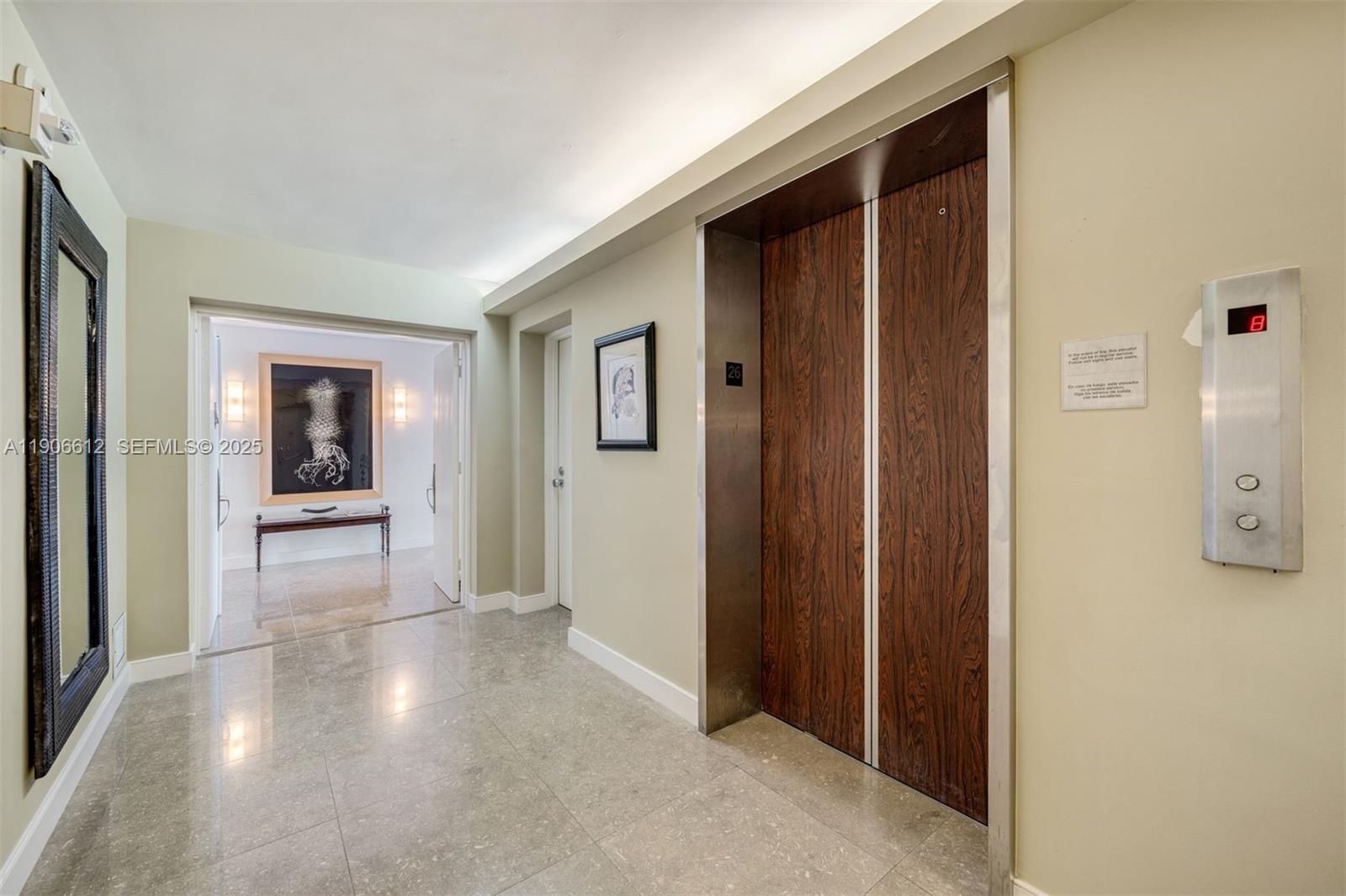 881 Ocean Drive, Unit 26B Key Biscayne, FL 33149 - Photo 13 of 34 a view of a hallway with wooden floor and a bathroom