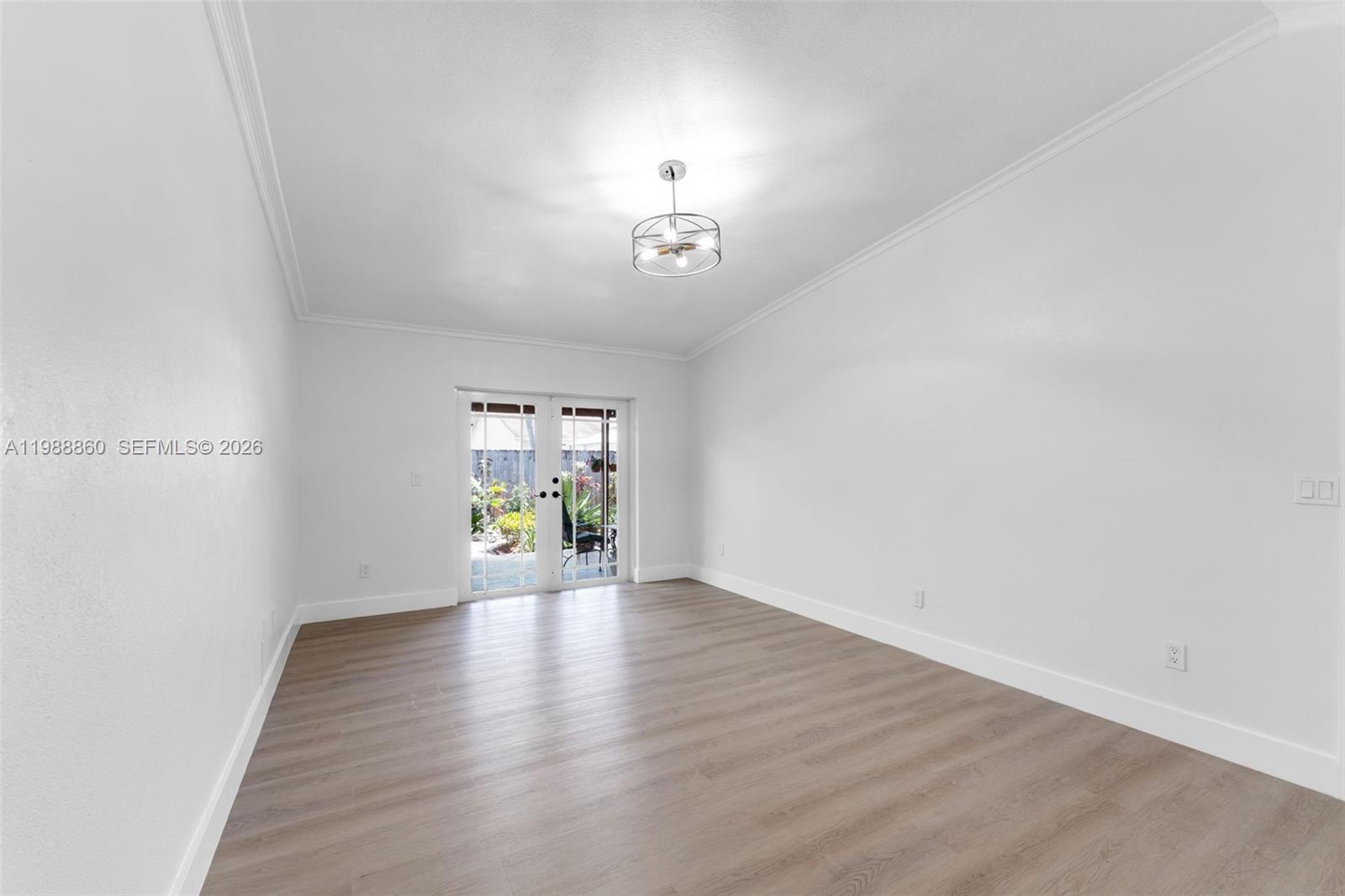 10021 Southwest 145th Place Miami, FL 33186 - Photo 12 of 44 a view of an empty room with wooden floor and a window
