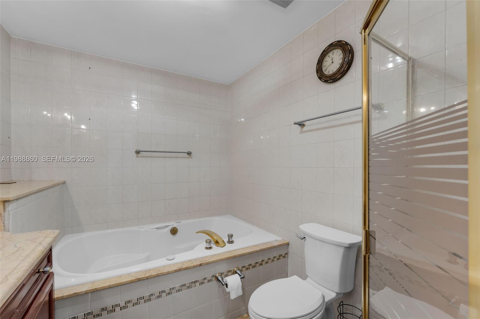 10021 Southwest 145th Place Miami, FL 33186 - Photo 18 of 44 a bathroom with a toilet sink a mirror a bathtub and shower