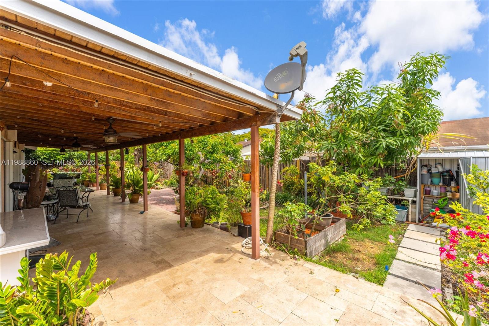 10021 Southwest 145th Place Miami, FL 33186 - Photo 27 of 44 a view of a patio with table and chairs potted plants with wooden floor