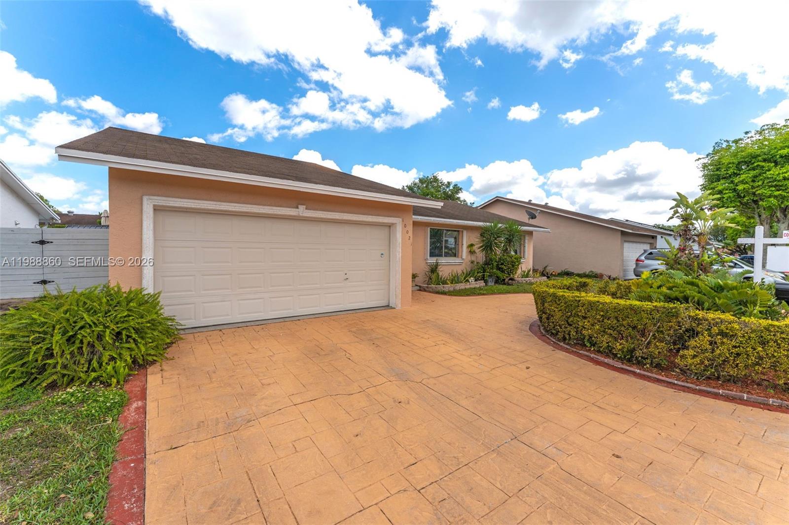 10021 Southwest 145th Place Miami, FL 33186 - Photo 3 of 44 a front view of a house with a yard and garage