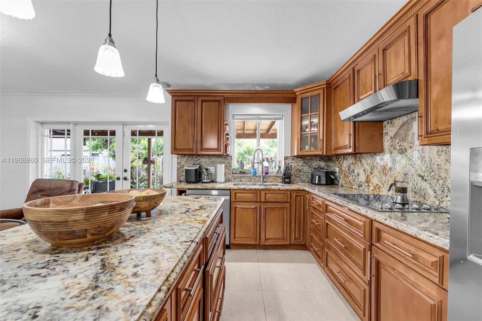 10021 Southwest 145th Place Miami, FL 33186 - Photo 9 of 44 a kitchen with kitchen island granite countertop a sink stove and cabinets