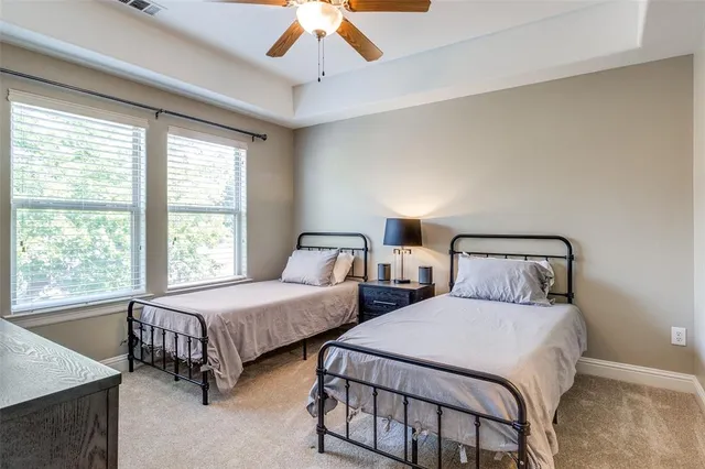 a bedroom with two beds and a chandelier