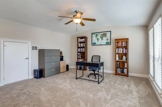 a view of a workspace with furniture and a window