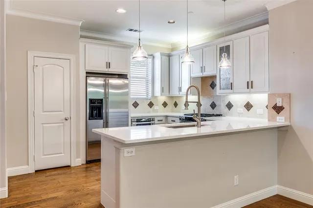 a kitchen with kitchen island a sink stainless steel appliances and cabinets