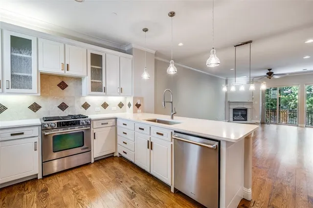 a kitchen with granite countertop a sink stainless steel appliances and cabinets