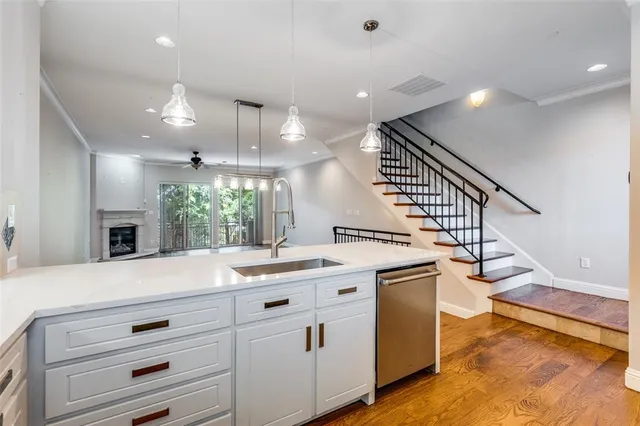 a open kitchen with kitchen island a stove a sink and dishwasher with wooden floor
