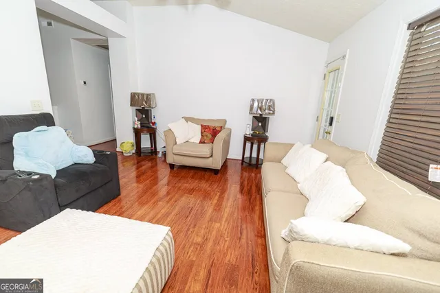 a living room with furniture and a wooden floor