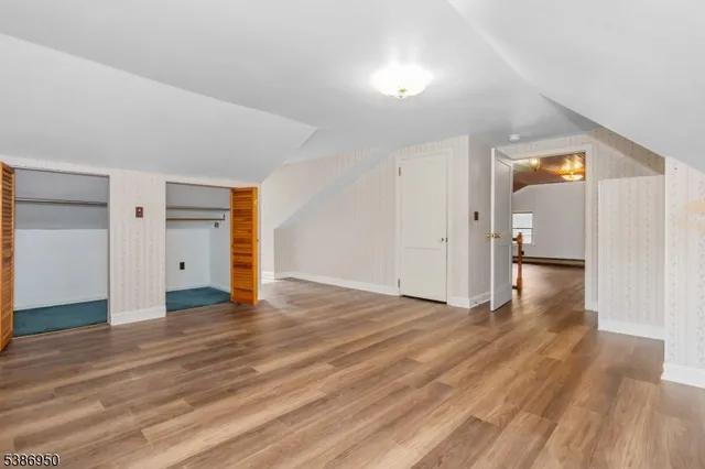 a view of empty room with wooden floor