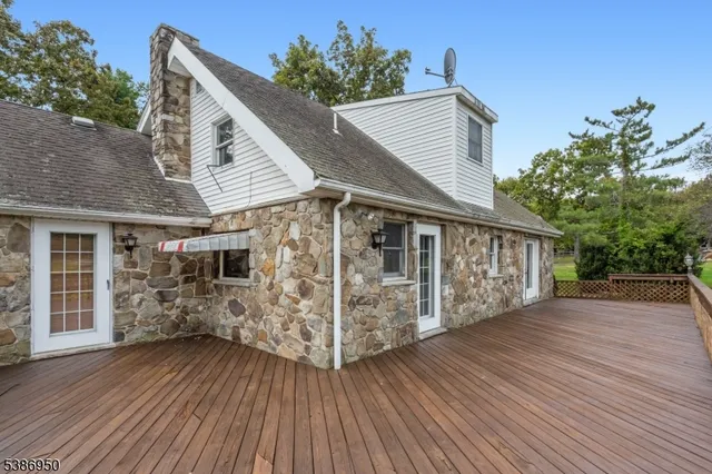 a view of a house with wooden deck and a yard