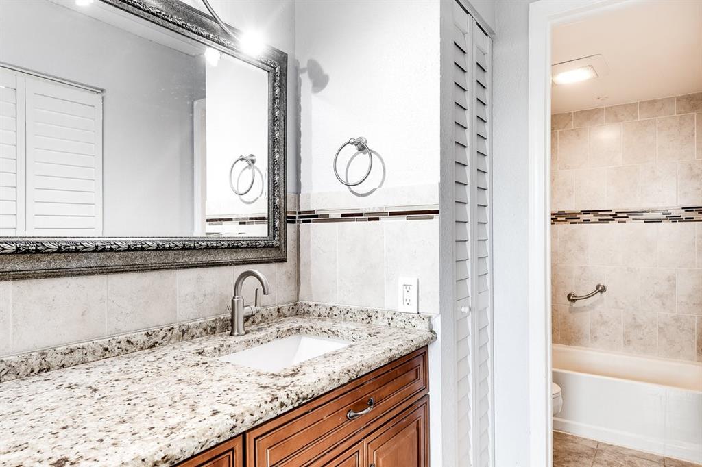 9080 Lime Bay Boulevard, Unit 109 Tamarac, FL 33321 - Photo 11 of 49 a bathroom with a granite countertop sink and a mirror
