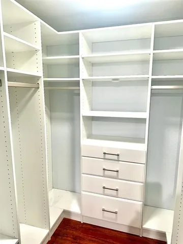 a view of walk in closet with empty racks