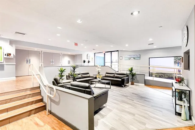 a living room with stainless steel appliances kitchen island granite countertop a table and chairs in it