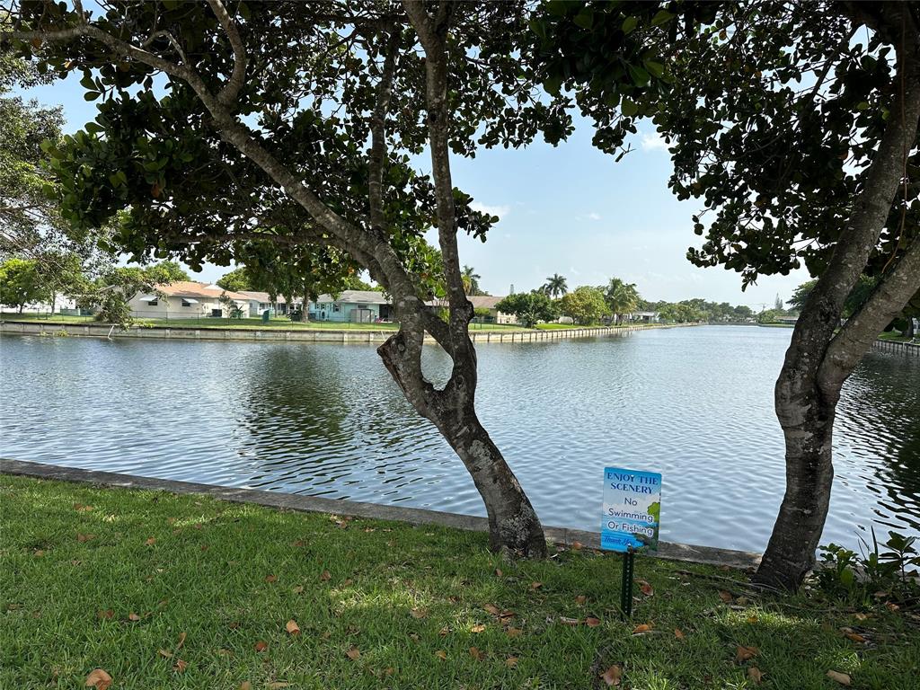 9080 Lime Bay Boulevard, Unit 109 Tamarac, FL 33321 - Photo 42 of 49 a view of a lake with a bench and trees