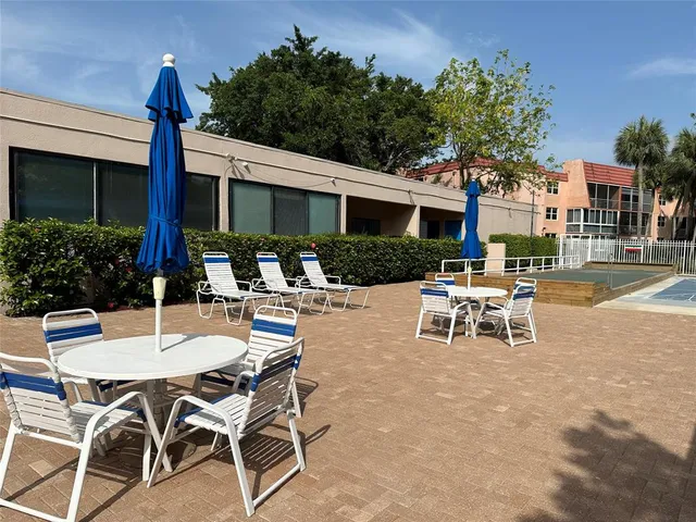 a view of a patio with a table and chairs and potted plants
