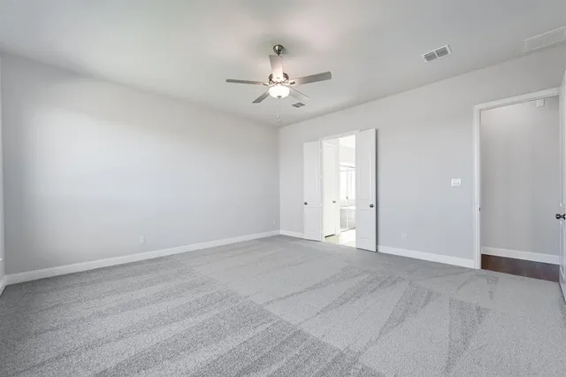 an empty room with fan and a ceiling fan
