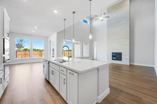 a kitchen with a stove and wooden floor