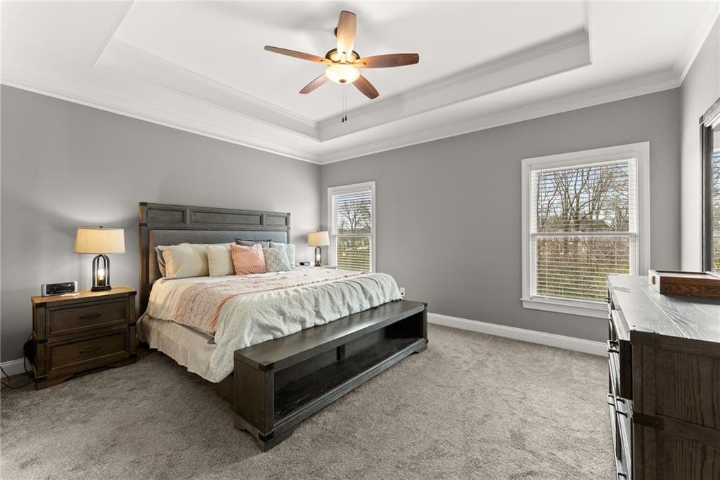 5716 Brickhampton Court Clermont, GA 30527 - Photo 16 of 42 a spacious bedroom with a bed and a chandelier
