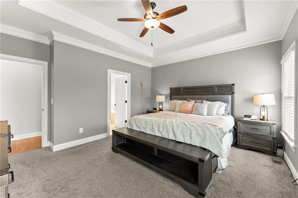 5716 Brickhampton Court Clermont, GA 30527 - Photo 17 of 42 a spacious bedroom with a bed and a ceiling fan