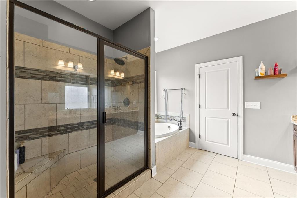 5716 Brickhampton Court Clermont, GA 30527 - Photo 19 of 42 a bathroom with a glass shower door and a mirror