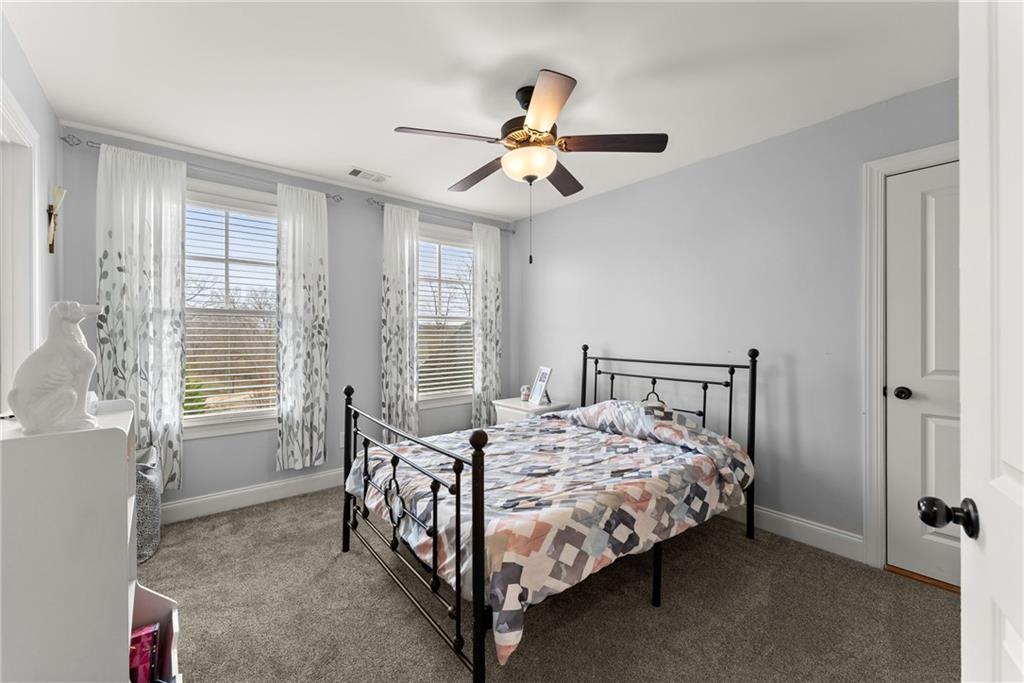 5716 Brickhampton Court Clermont, GA 30527 - Photo 23 of 42 a bedroom with a bed and a chandelier