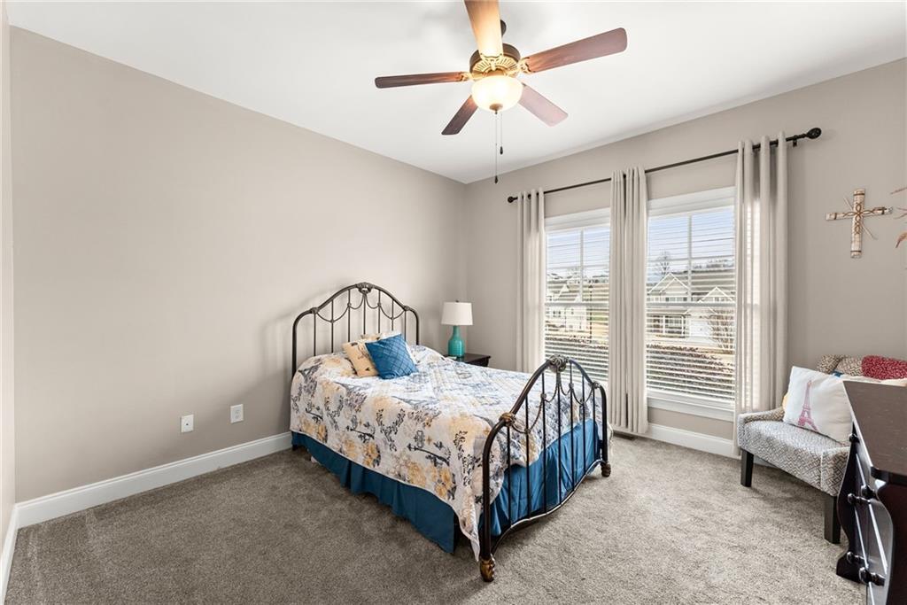 5716 Brickhampton Court Clermont, GA 30527 - Photo 24 of 42 a bedroom with a bed next to a large window