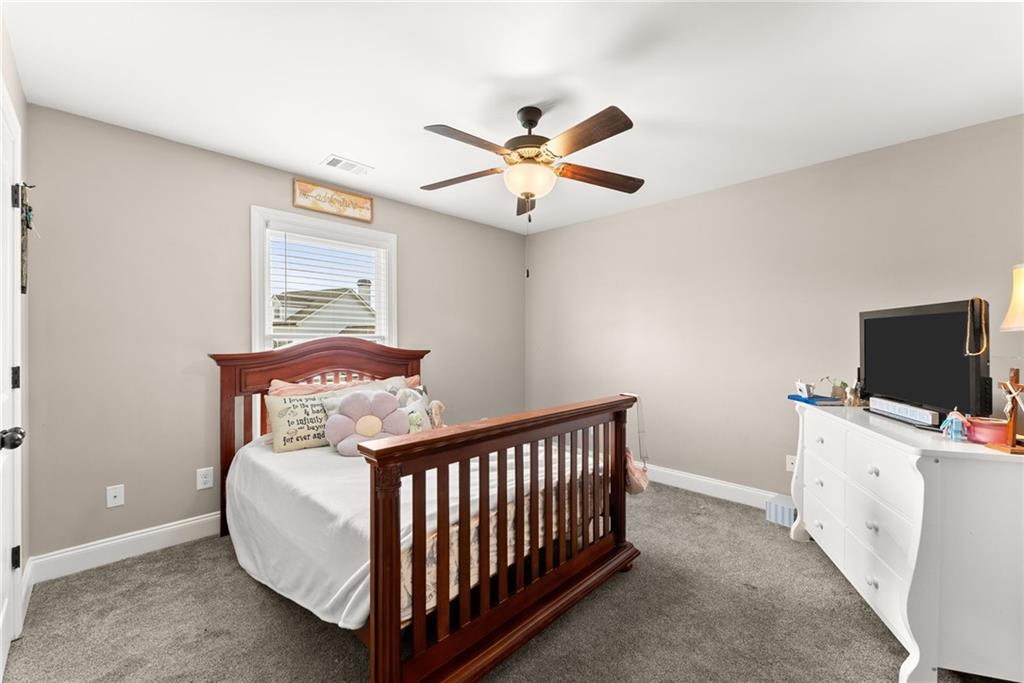5716 Brickhampton Court Clermont, GA 30527 - Photo 25 of 42 a bedroom with furniture and a flat screen tv