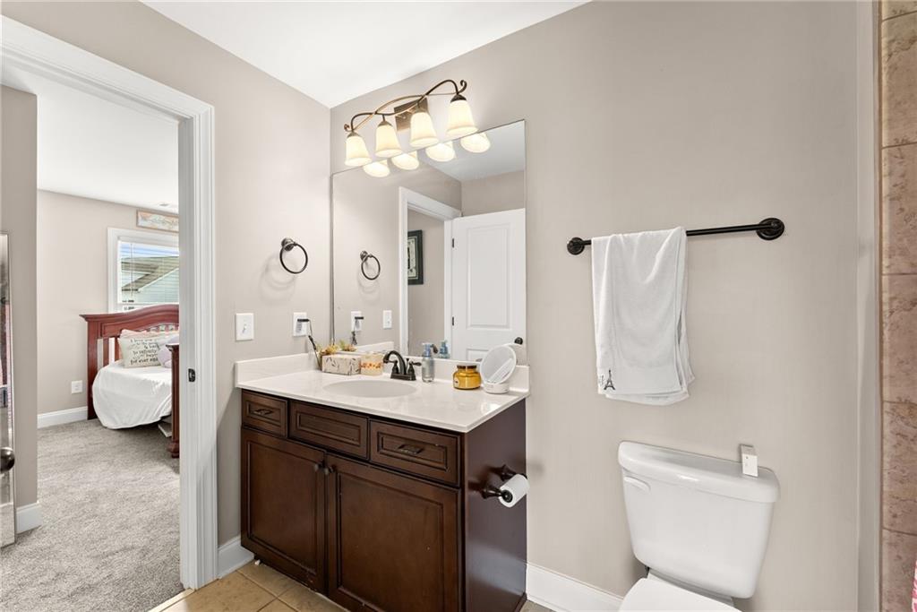 5716 Brickhampton Court Clermont, GA 30527 - Photo 26 of 42 a bathroom with a sink vanity mirror and toilet