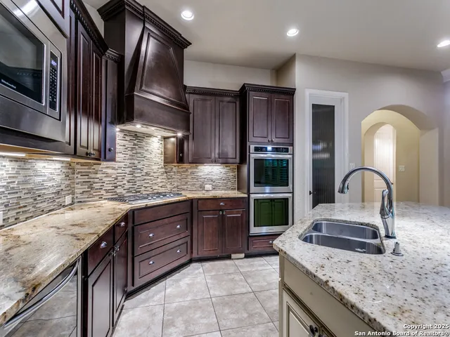 a kitchen with stainless steel appliances granite countertop a sink and stove