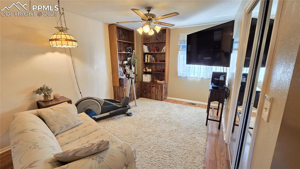 7231 South Webster Street Littleton, CO 80128 - Photo 14 of 44 Living room featuring light wood-style flooring, ceiling fan, and built in shelves