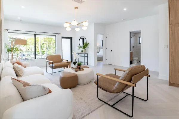 a living room with furniture or chandelier and a large window