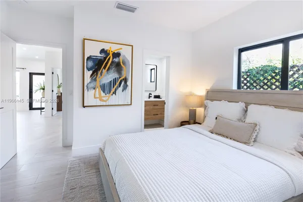 a bedroom with a large bed and a painting on the wall
