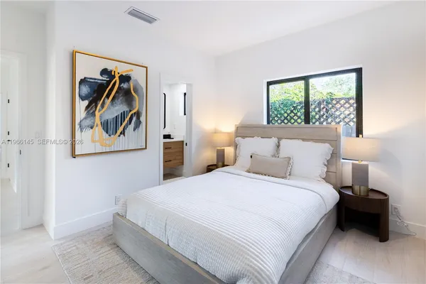 a bedroom with a bed and a painting on the wall