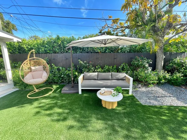 a front view of a house with garden and sitting area