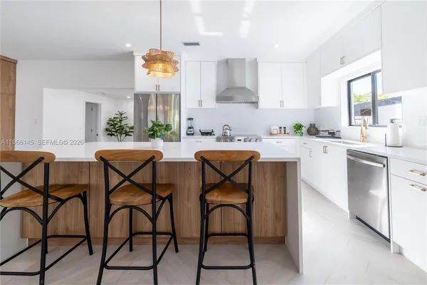 a kitchen with stainless steel appliances granite countertop table chairs sink and cabinets