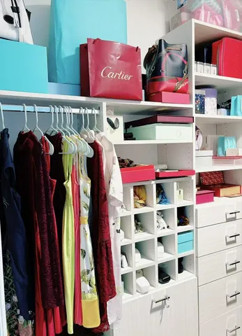a view of walk in closet with clothes and shoes